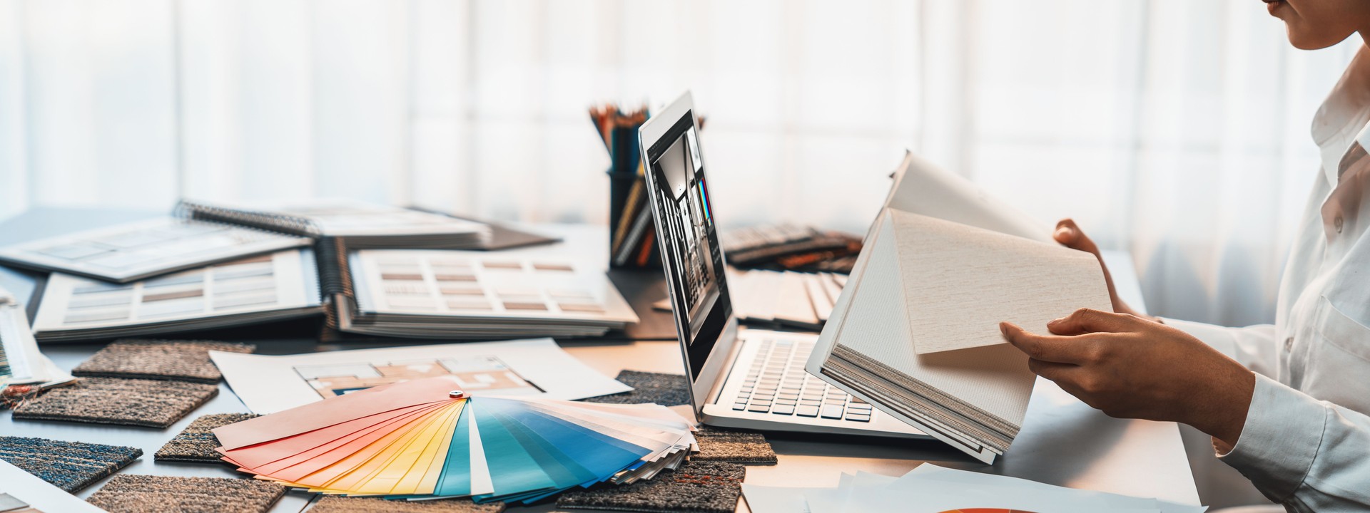 Interior architect designer at table choosing color sample. Insight