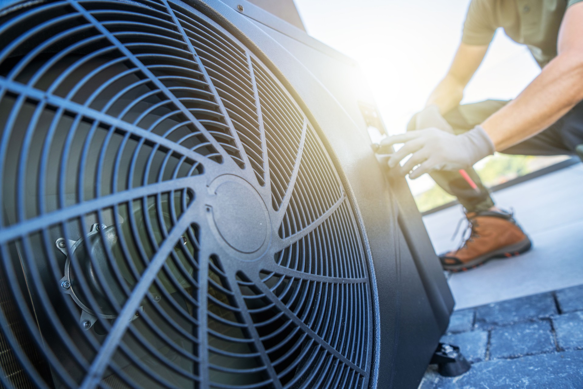 Technician Servicing Air Conditioning Unit on Rooftop During Daytime
